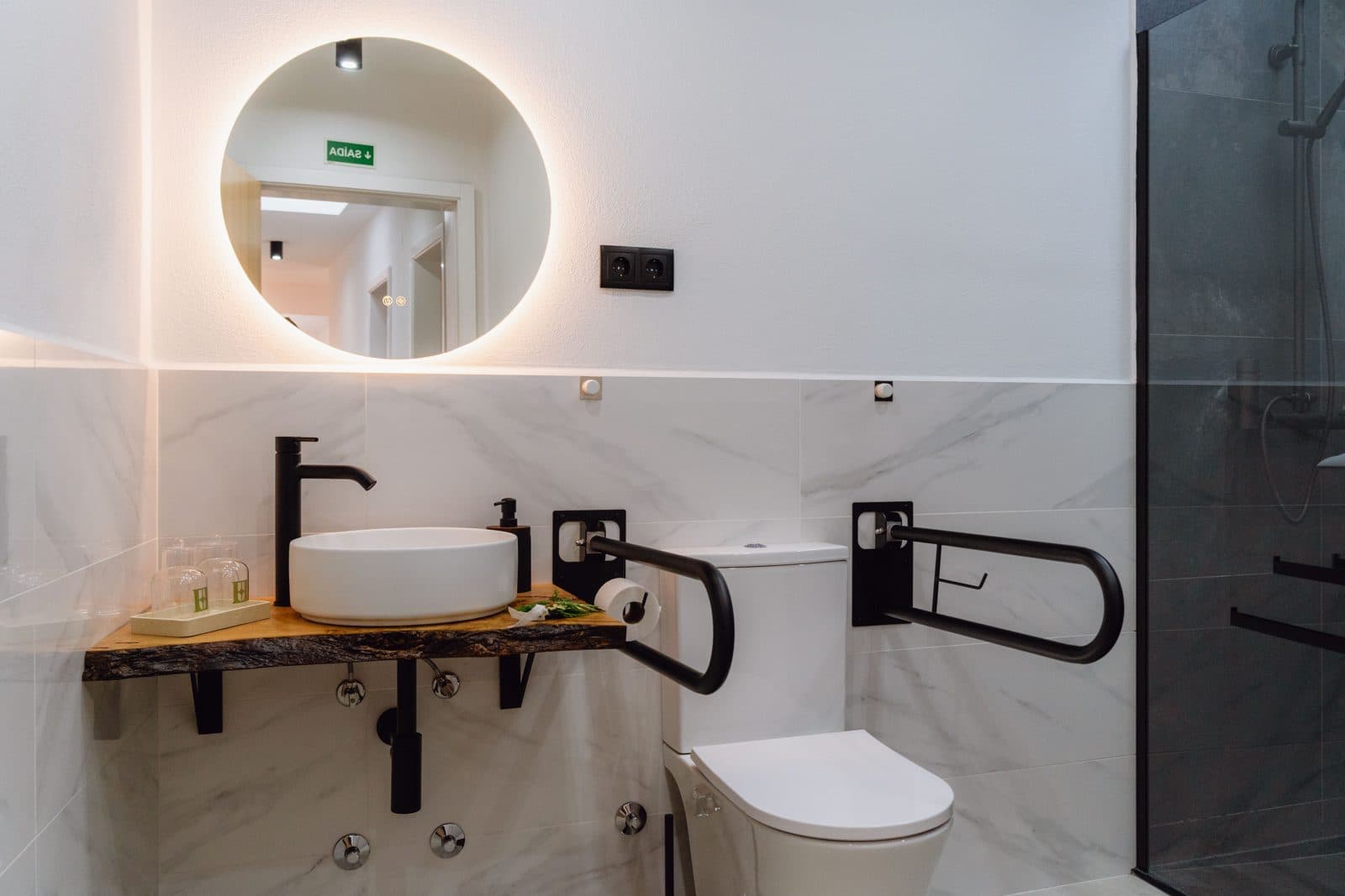Casa de banho adaptada com duche walk-in, banco rebatível e barras de apoio — vista 3